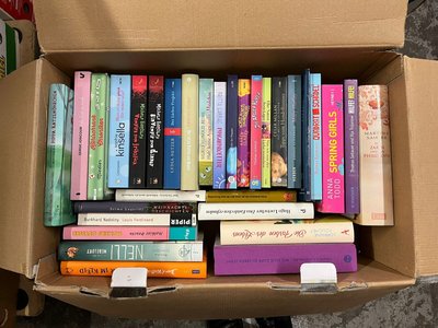 Beispielfoto für Buchspenden: Draufsicht auf einen Karton voller Bücher. Die einzelnen Titel auf den Buchrücken sind zu erkennen.