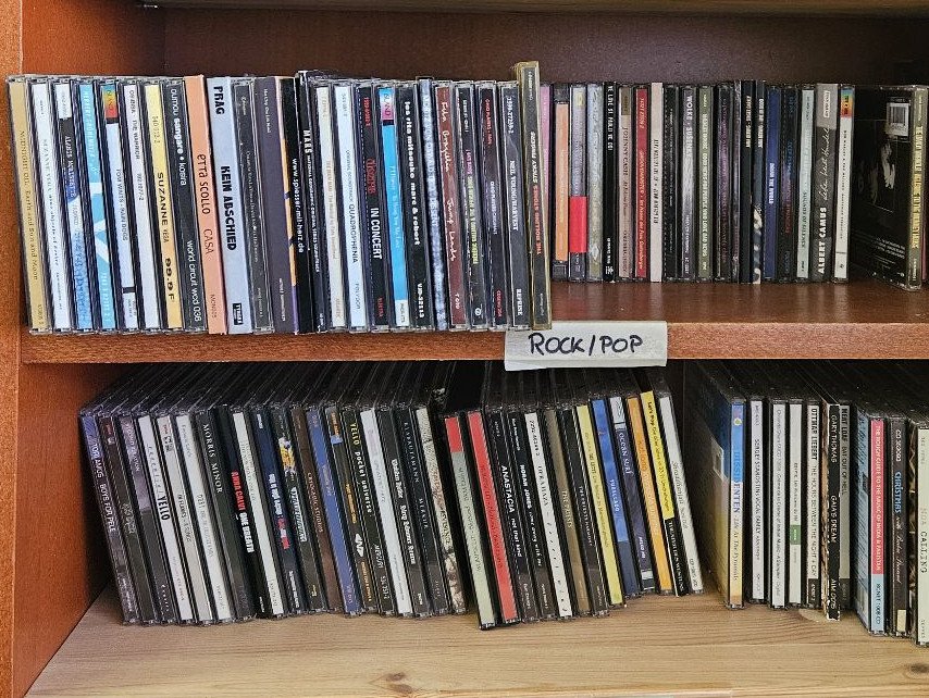 Beispielfoto für CD-Spenden: Frontalansicht von CDs im Regal. Die einzelnen Titel auf den CD-Rücken sind zu erkennen.